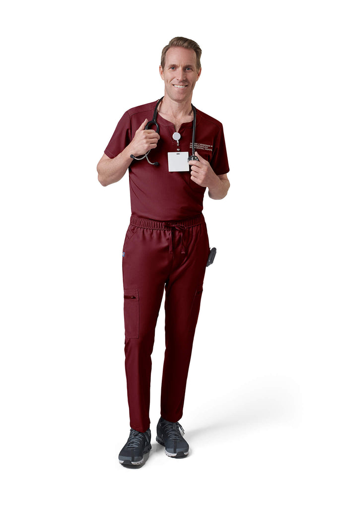 Man wearing MedTailor men's custom scrub top in Merlot Red color fabric