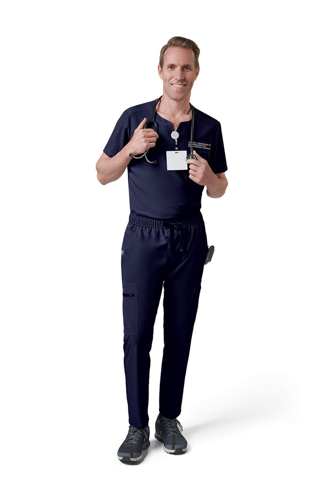 Man wearing MedTailor men's custom scrub top in Navy Blue color fabric