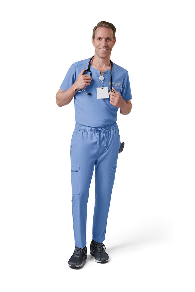 Man wearing MedTailor men's custom scrub top in Sky Blue color fabric