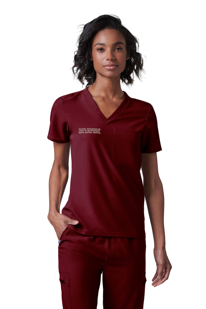 Woman wearing MedTailor women's scrub top in Merlot Red color fabric