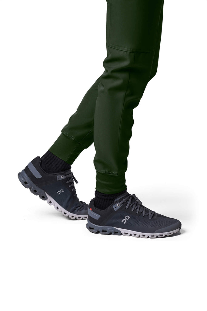 Man wearing MedTailor men's custom scrub pants in Highland Green color fabric