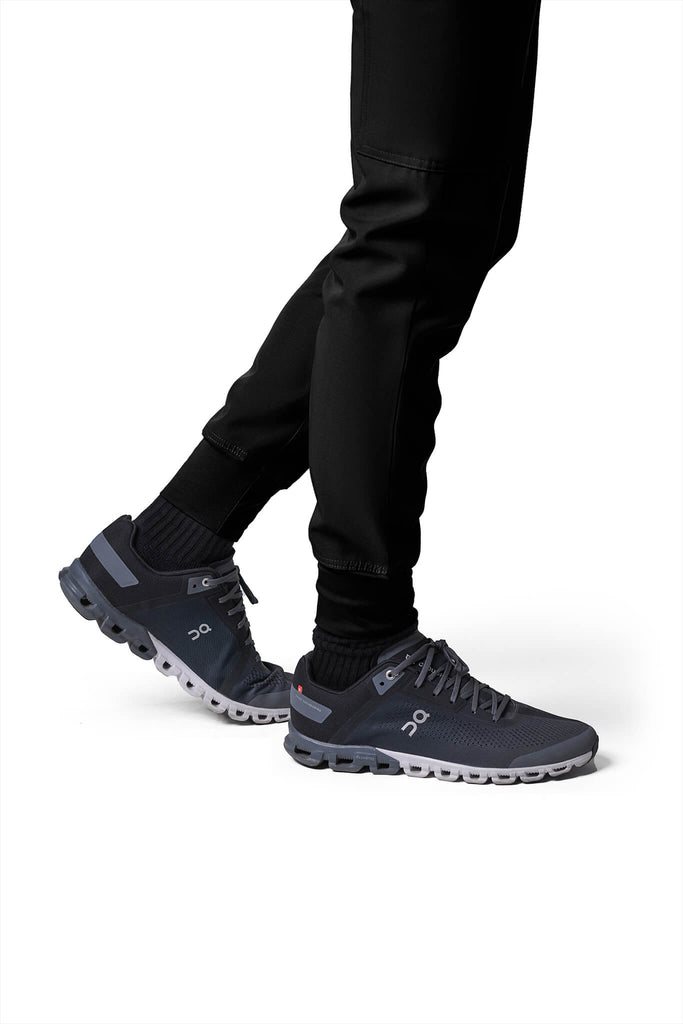 Man wearing MedTailor men's custom scrub pants in Jet Black color fabric