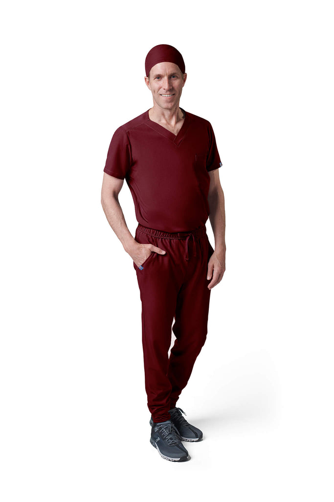 Man wearing MedTailor men's custom scrub cap in Merlot Red color fabric