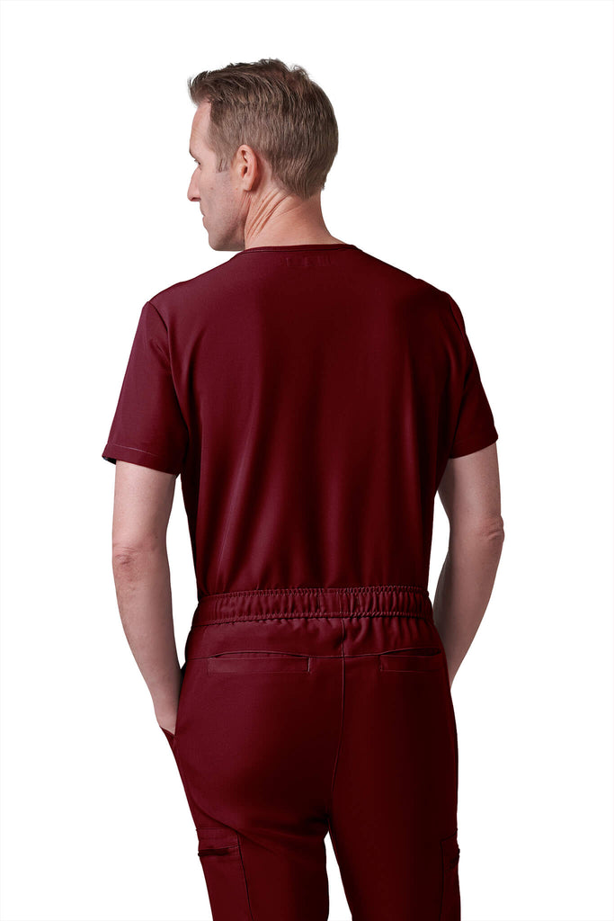 Man wearing MedTailor men's custom scrub pants in Merlot Red color fabric