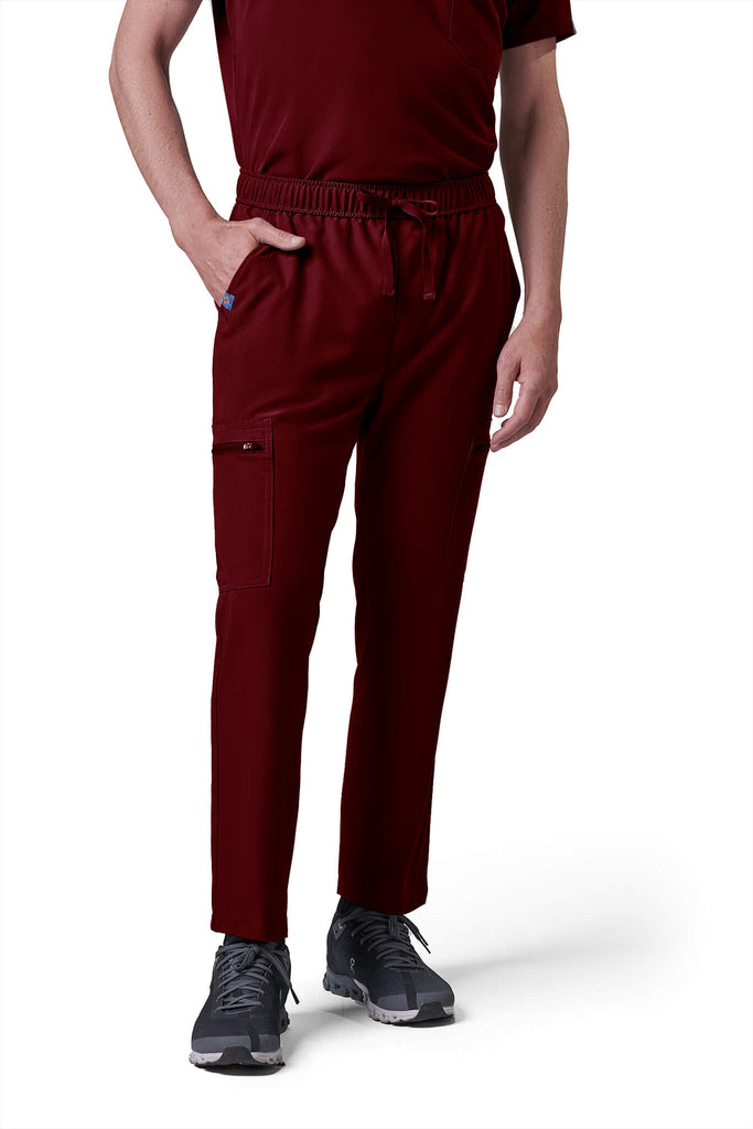 Man wearing MedTailor men's custom scrub pants in Merlot Red color fabric