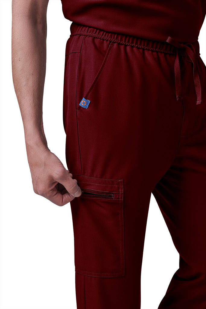 Man wearing MedTailor men's custom scrub pants in Merlot Red color fabric