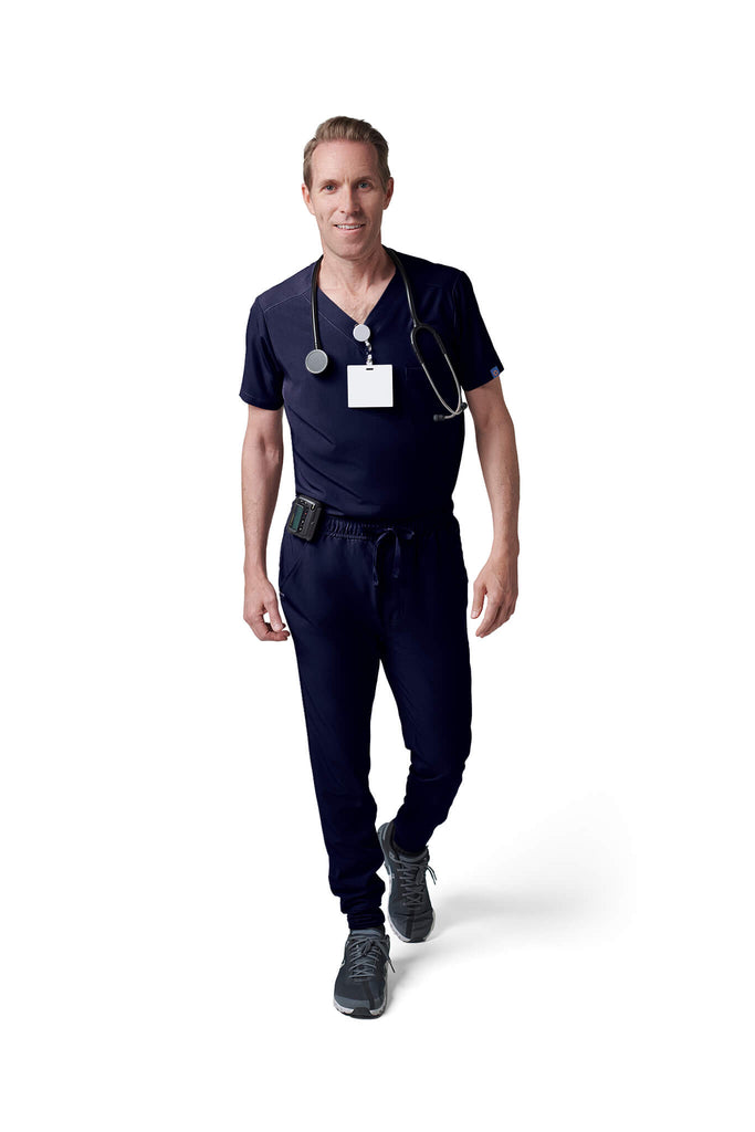 Man wearing MedTailor men's custom scrub pants in Navy Blue color fabric