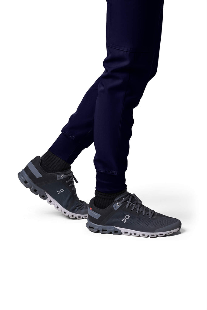 Man wearing MedTailor men's custom scrub pants in Navy Blue color fabric