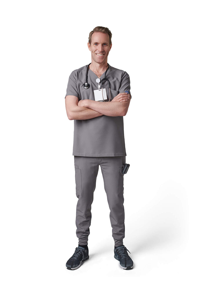 Man wearing MedTailor men's custom scrub pants in Platinum Gray color fabric