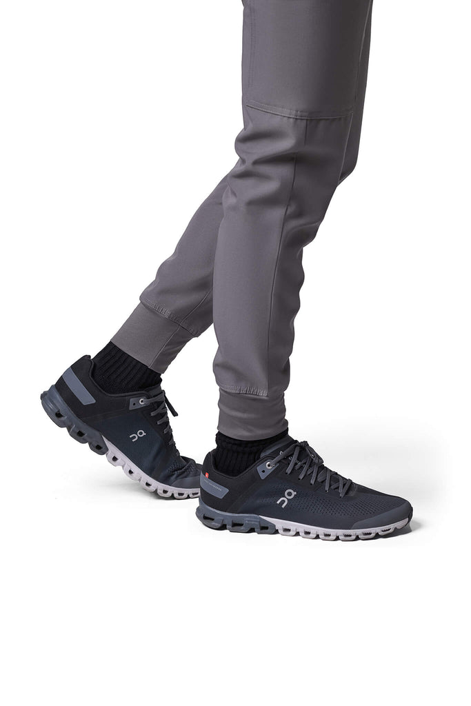 Man wearing MedTailor men's custom scrub pants in Platinum Gray color fabric