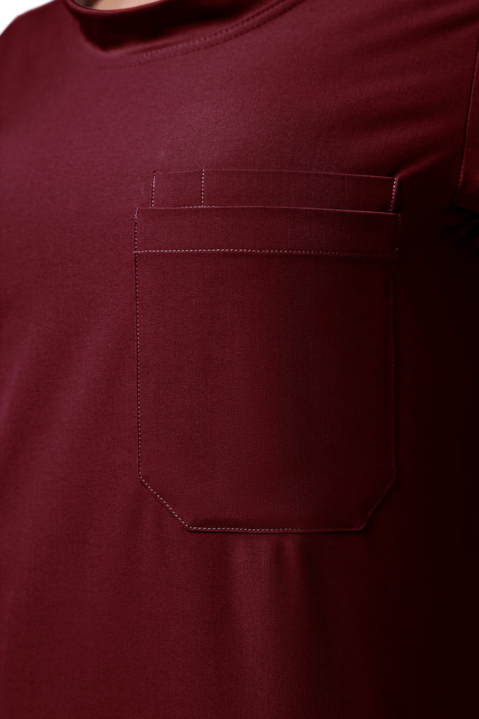 Man wearing MedTailor men's custom scrub top in Merlot Red color fabric