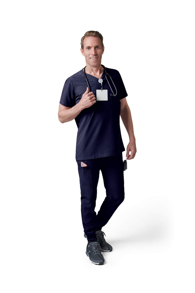 Man wearing MedTailor men's custom scrub top in Navy Blue color fabric