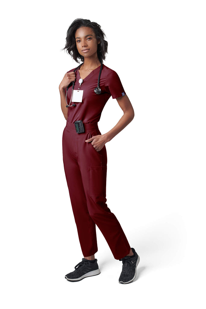Woman wearing MedTailor women's scrub pants in Merlot Red color fabric