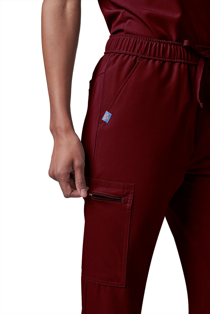 Woman wearing MedTailor women's scrub pants in Merlot Red color fabric