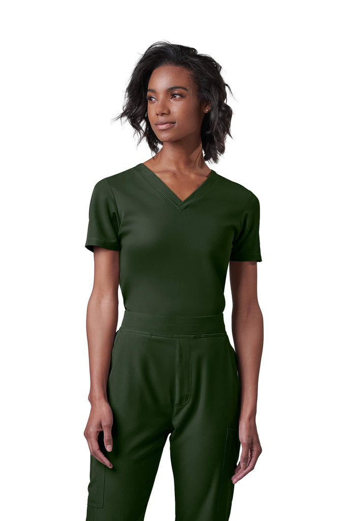 Woman wearing MedTailor women's scrub top in Highland Green color fabric