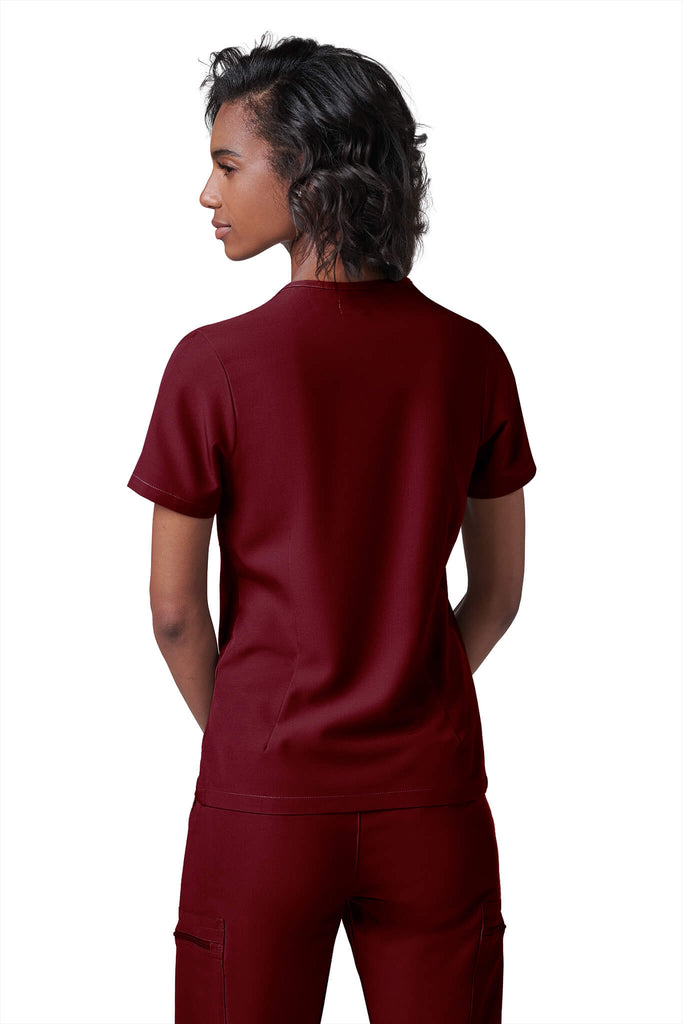 Woman wearing MedTailor women's scrub top in Merlot Red color fabric
